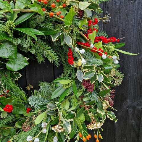 Biodegradable funeral wreath made with seasonal foliage on a mossed base.