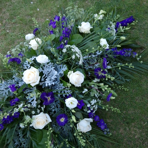 Seasonal coffin spray in purple white flowers