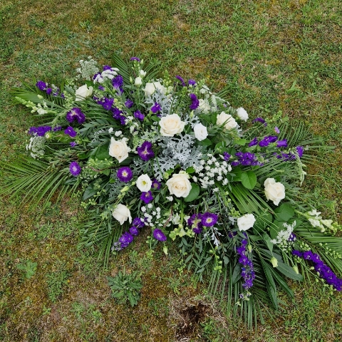 Seasonal coffin spray in purple white flowers