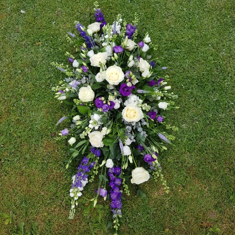 Seasonal coffin spray in purple white flowers