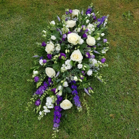 Seasonal coffin spray in purple white flowers
