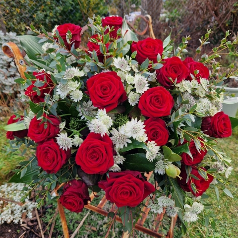 A hand‑tied luxury Valentine’s bouquet of premium red roses, delicate white Astrantia and natural foliage, gift‑wrapped and presented in a kraft water‑holding bouquet box.