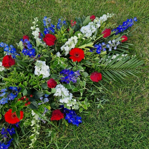Seasonal coffin spray in red, white and blue flowers
