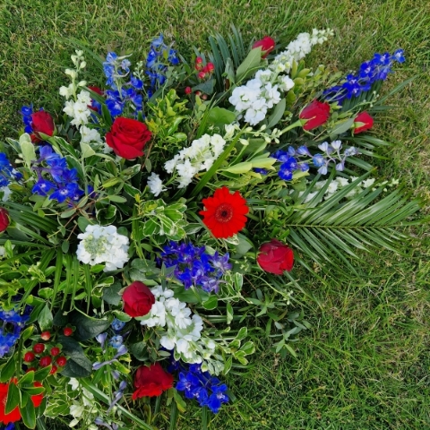 Seasonal coffin spray in red, white and blue flowers