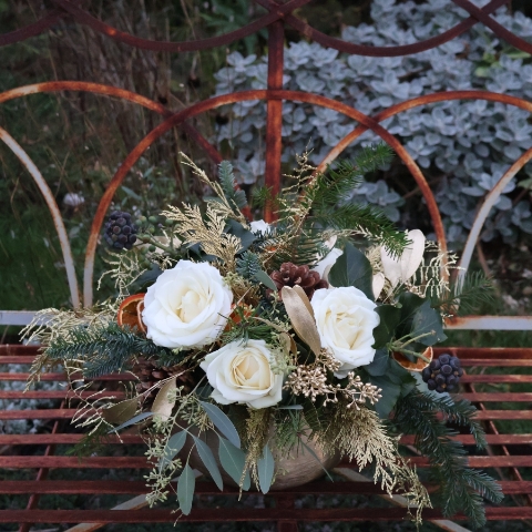 The Gilded Rose arrangement with white roses, gold eucalyptus, fresh pine, conifer, and ivy berry in a brushed gold bowl