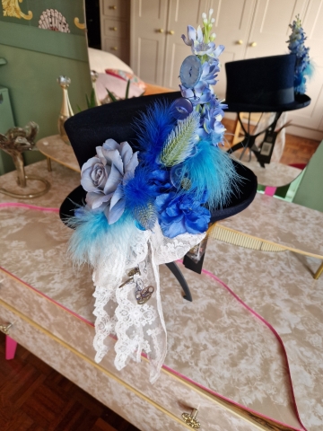 Navy wool top hat with structured crown and detachable faux flowers, or Goggles ideal for weddings or steampunk events.