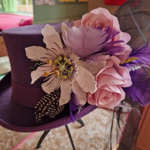 Alternative wedding top hat in purple wool with removable floral detail.