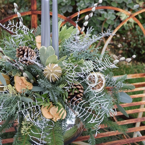 Twinkle Twinkle candle arrangement with silver candles, fresh pine, eucalyptus, dried citrus, and pine cones on a mirrored glass vase.